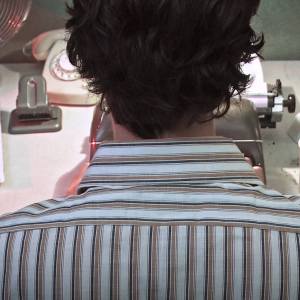 Still from the film Nowhere Place. The writer is sitting in front of the typewriter and we are seeing the back of his head and his shoulders.