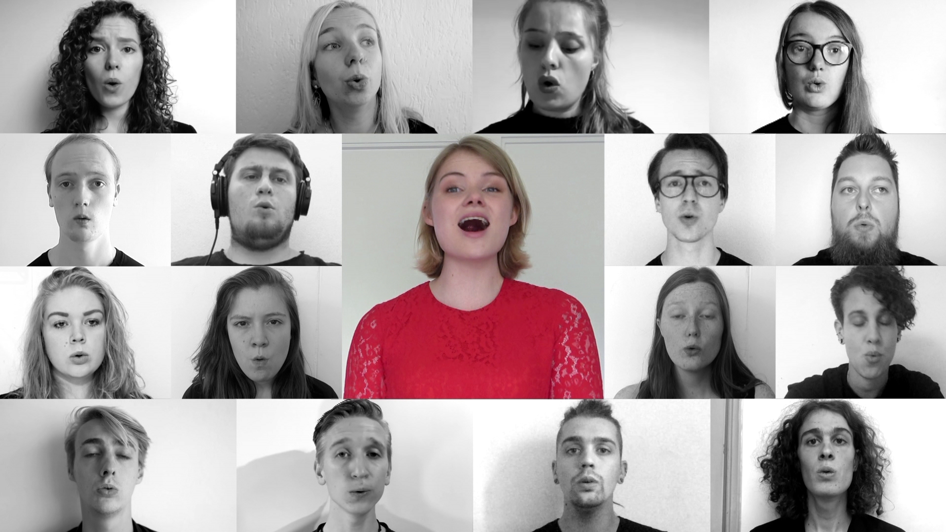 Still from Groei - Suzanne de Jong. A splitscreen edit of a choir with 17 different singers, all have their own close-up shots. All are in black and white except for Suzanne, who is wearing a red dress with lace details.