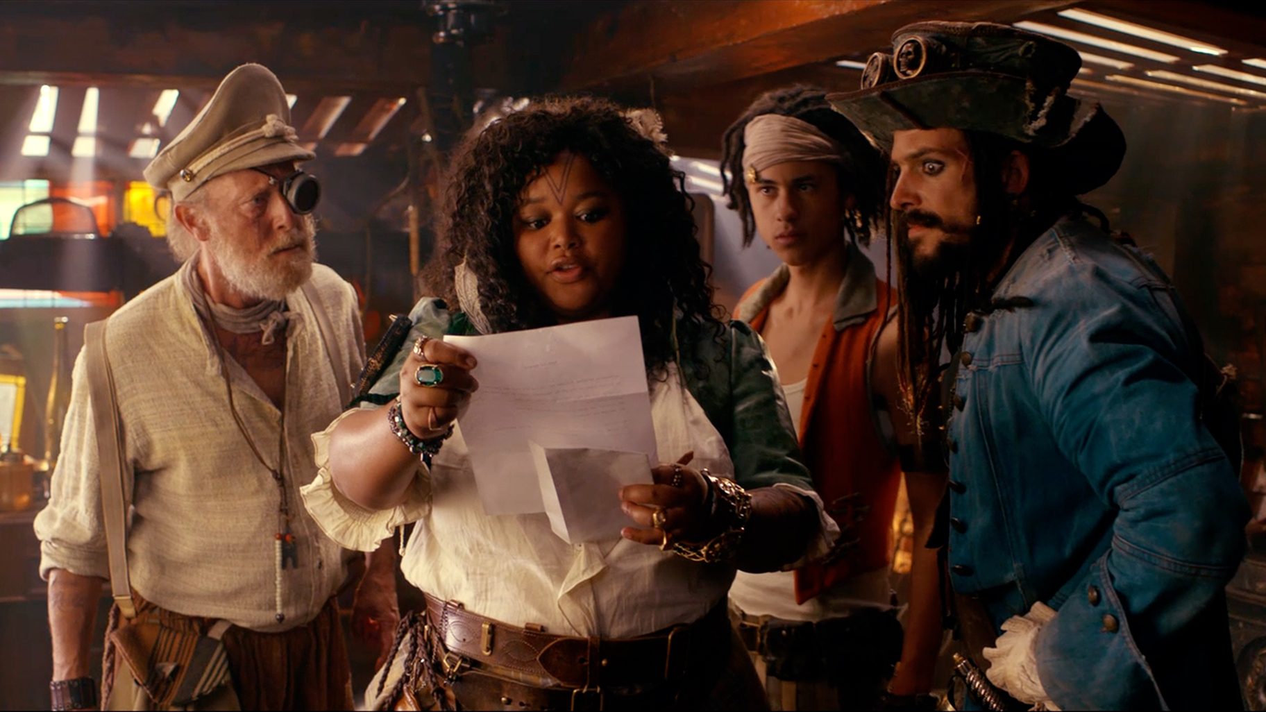 Still from De Piraten van Hiernaast 2. The pirate family is standing below deck, reading a letter.