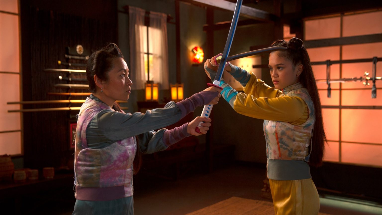 Still from De Piraten van Hiernaast 2. Yuka is training in katana sword fighting with her mom, Mia. The swords are crossed in the middle.