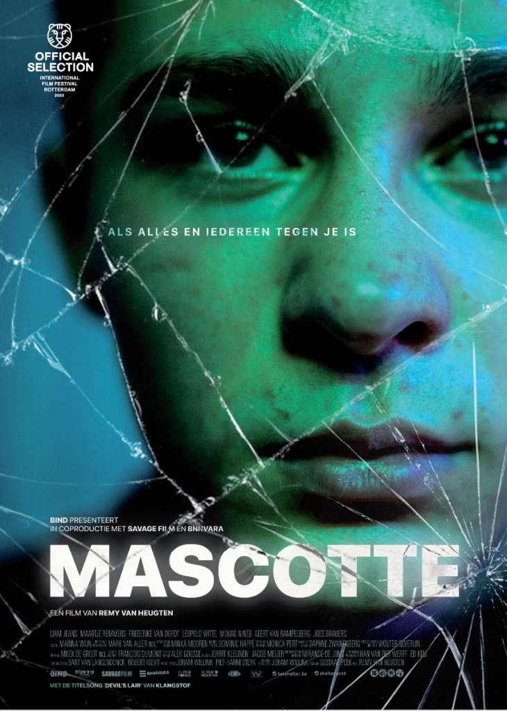 Poster for the film 'Mascotte'. It's a very blue/green tinted close-up picture of the main character, Jerry (a white teenaged boy). He's slightly off-centre to the right. Overlaid is a kind of effect of broken glass, as if the frame the poster is in is broken. At the botten it says 'MASCOTTE' in white letters.
